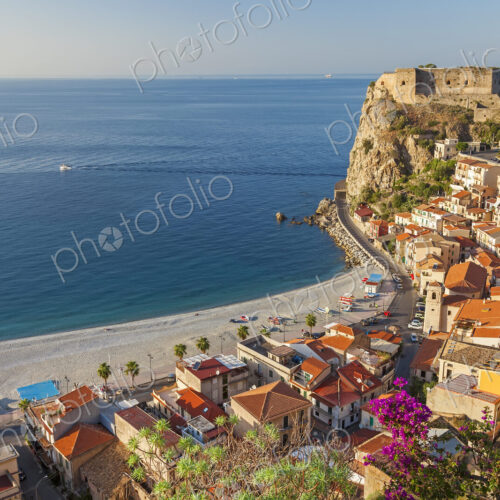 High angle view of seaside town with castle on cliff and sandy beach on the… High angle view of seaside town with castle on cliff and sandy beach on the…