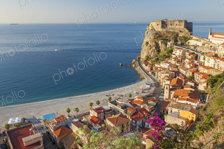 High angle view of seaside town with castle on cliff and sandy beach on the…