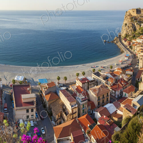 High angle view of seaside town with castle on cliff and sandy beach on the… High angle view of seaside town with castle on cliff and sandy beach on the…