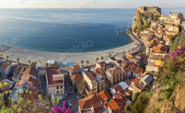 High angle view of seaside town with castle on cliff and sandy beach on the…