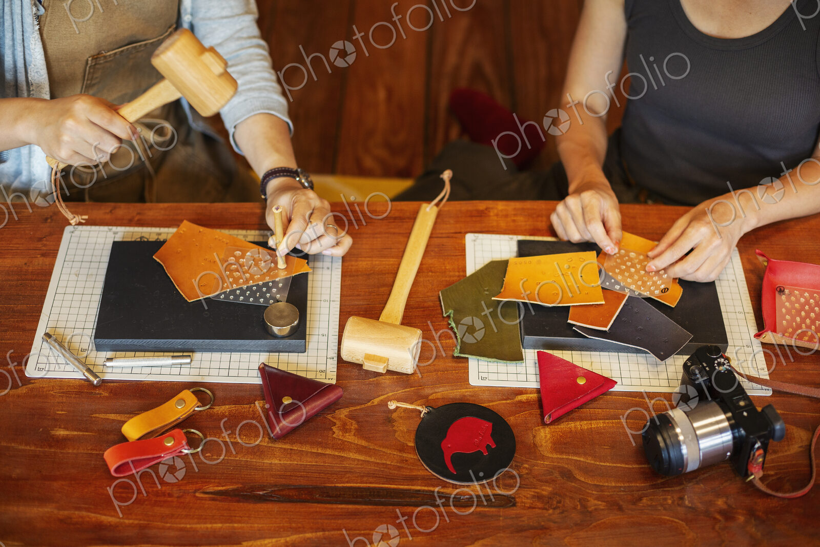 High angle view of two women sitting at a table, working in a leather shop.