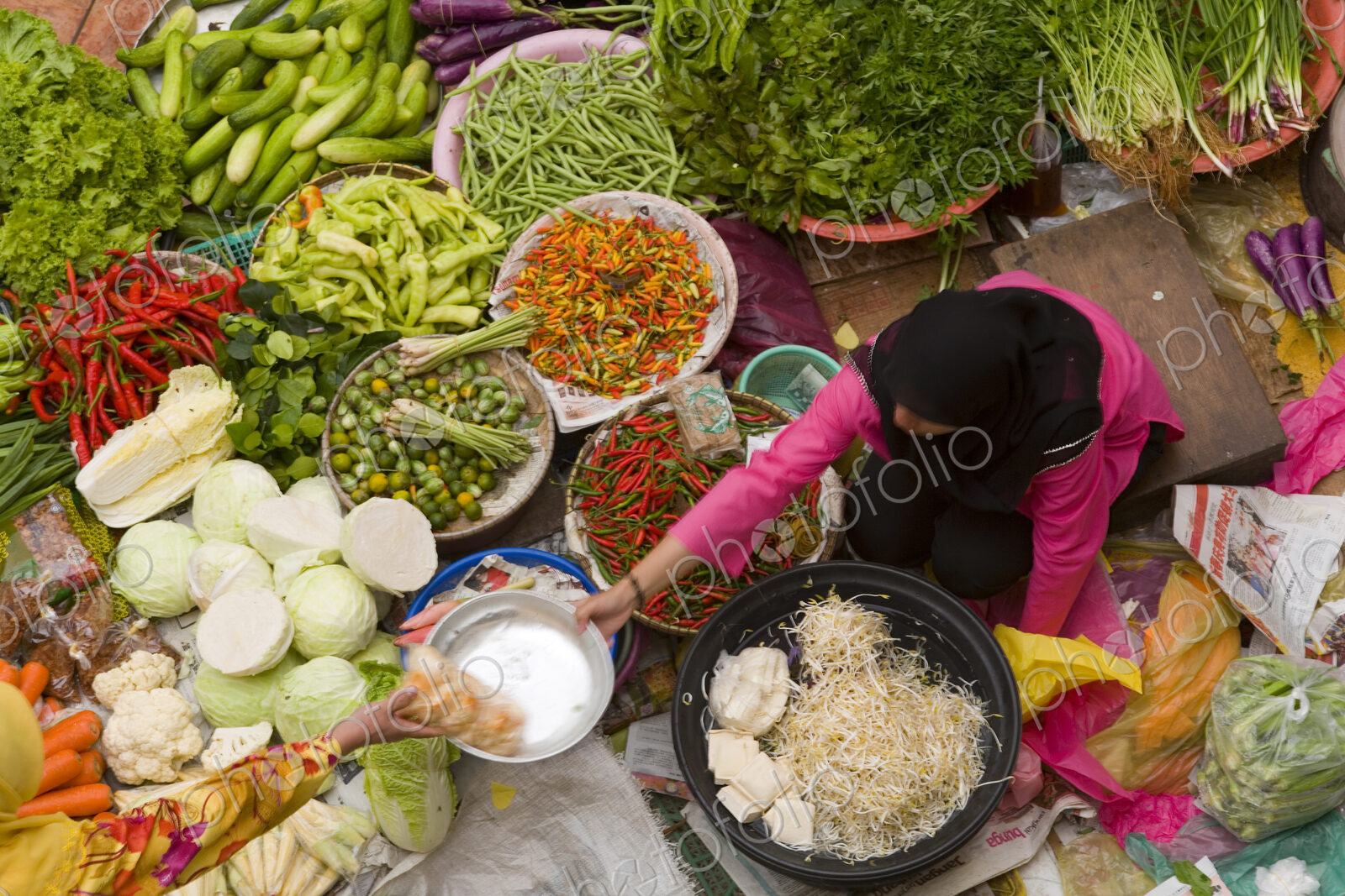 High angle view of vendor selling a selection of fresh vegetables on a street market.