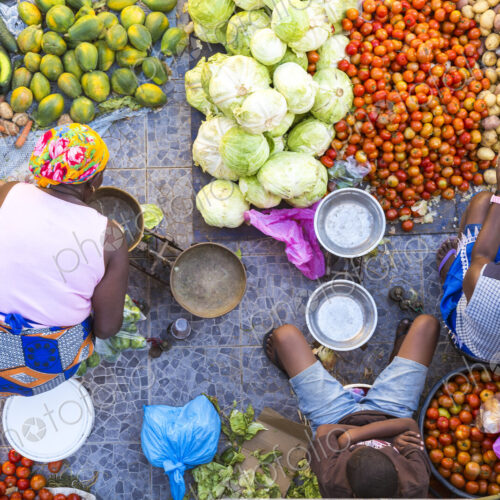 High angle view of vendors selling a selection of fresh vegetables on a street market.