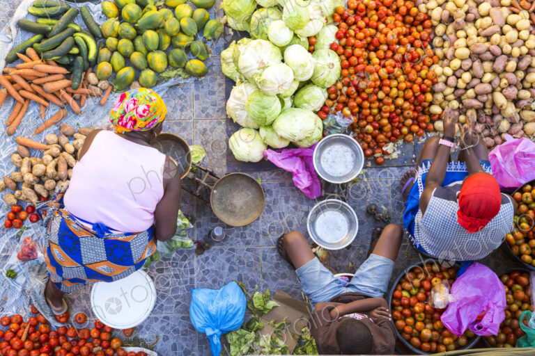 High angle view of vendors selling a selection of fresh vegetables on a street market.