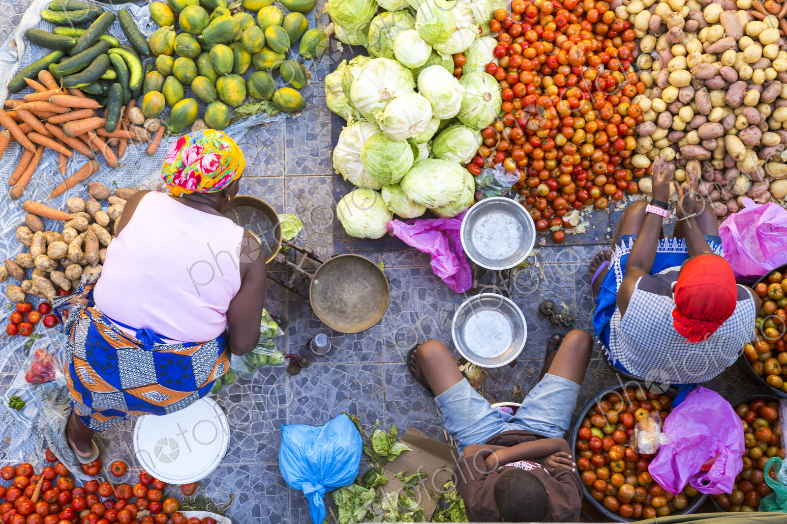High angle view of vendors selling a selection of fresh vegetables on a street market.