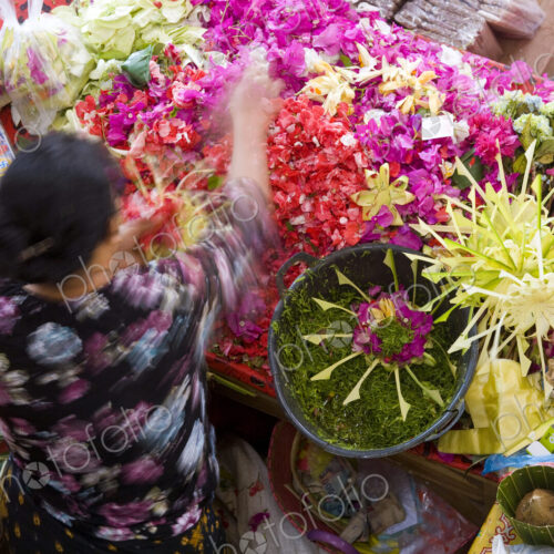 High angle view of woman at Asian flower market, flower arrangements and heaps of… High angle view of woman at Asian flower market, flower arrangements and heaps of…