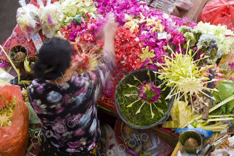 High angle view of woman at Asian flower market, flower arrangements and heaps of…
