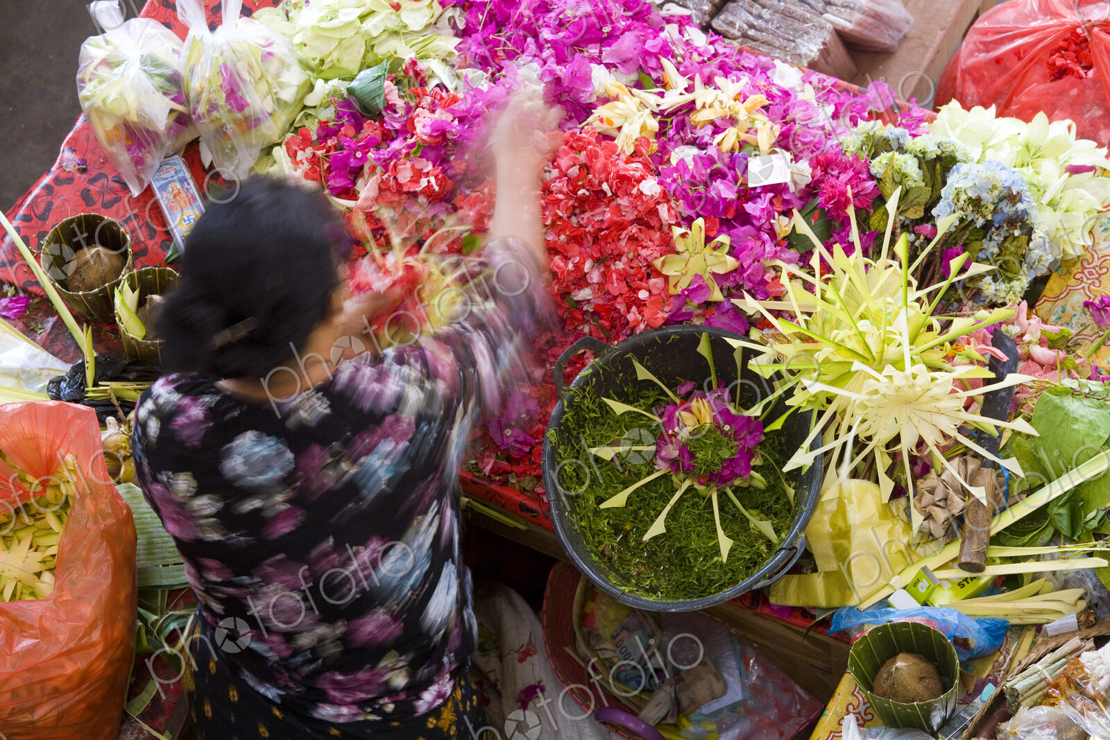 High angle view of woman at Asian flower market, flower arrangements and heaps of…