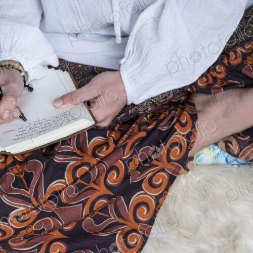 High angle view of woman wearing trousers with floral pattern sitting on shag carpet,… High angle view of woman wearing trousers with floral pattern sitting on shag carpet,…