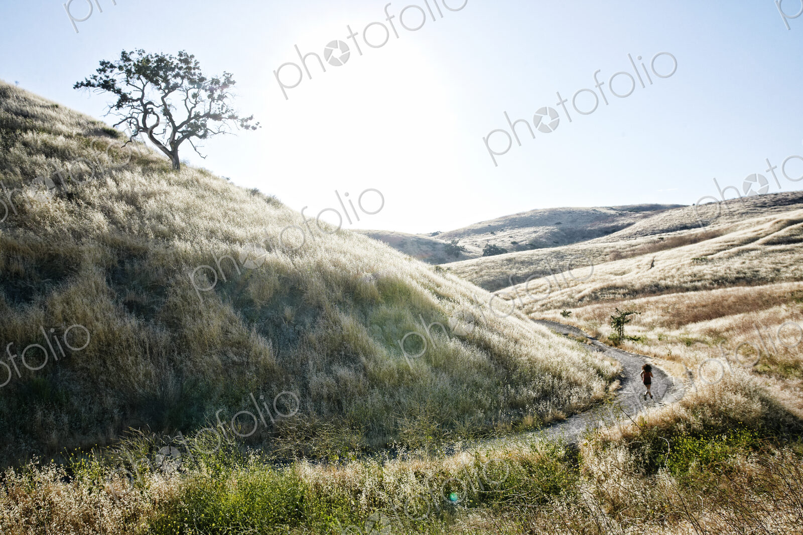 High angle view of young woman with curly brown hair hiking in urban park.