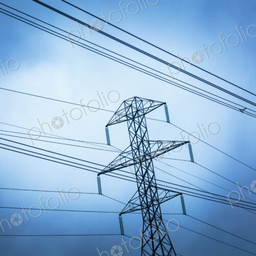 High transmission tower and wires seen from a low angle, overhead power cables. High transmission tower and wires seen from a low angle, overhead power cables.