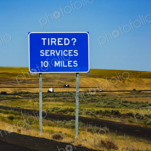 Highway rest area sign, Interstate 90 at Sprague, message reading Tired? Services 10… Highway rest area sign, Interstate 90 at Sprague, message reading Tired? Services 10…