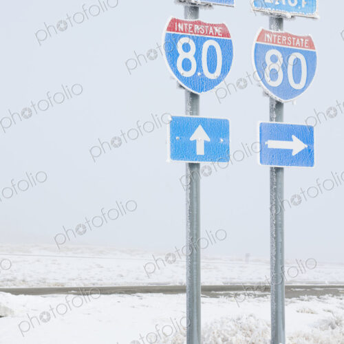 Highway signs on road in wintry snowy landscape.