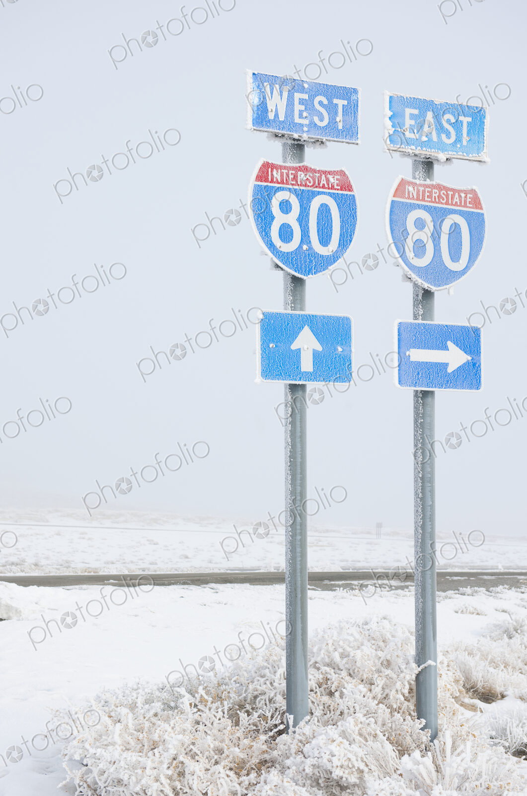 Highway signs on road in wintry snowy landscape.