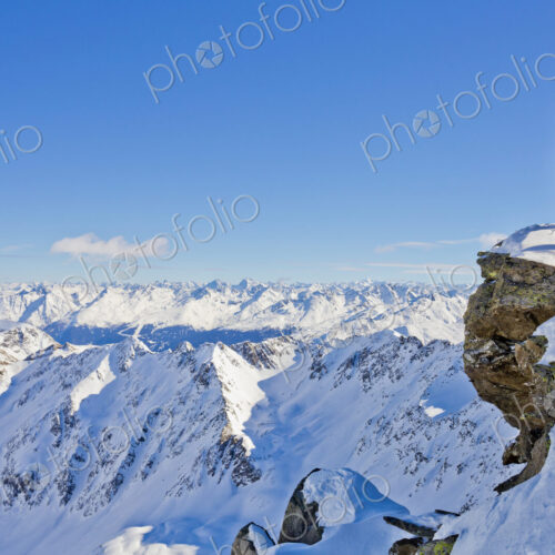 Hiker admiring scenic view from snowy mountaintop Hiker admiring scenic view from snowy mountaintop