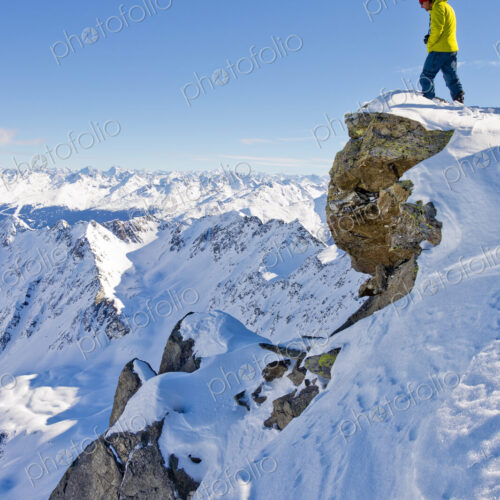 Hiker admiring scenic view from snowy mountaintop