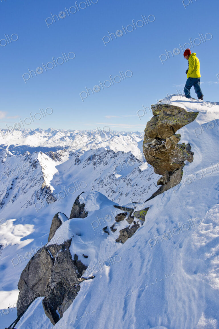 Hiker admiring scenic view from snowy mountaintop