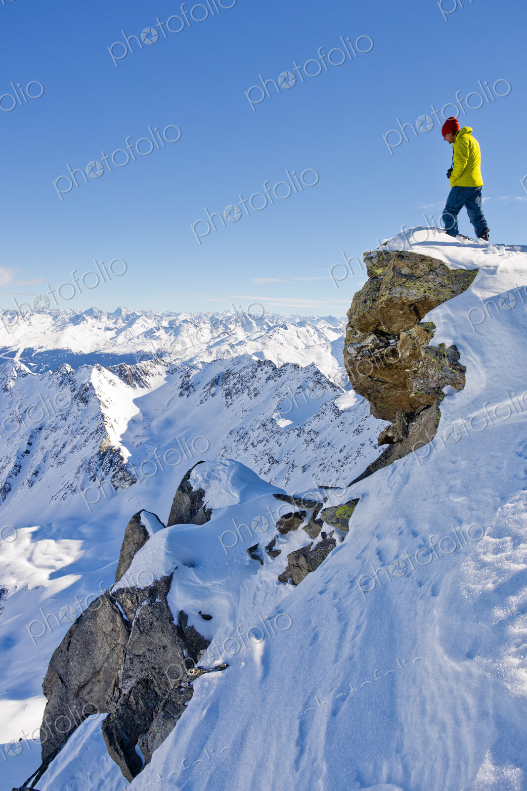 Hiker admiring scenic view from snowy mountaintop