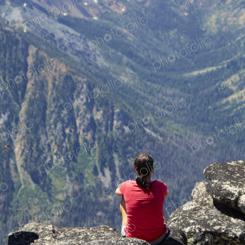 Hiker sitting on rocky hilltop Hiker sitting on rocky hilltop