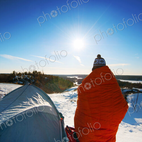 Hiker standing at snowy campsite