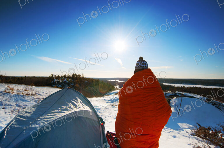 Hiker standing at snowy campsite