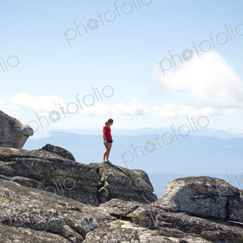 Hiker standing on hilltop in remote landscape Hiker standing on hilltop in remote landscape