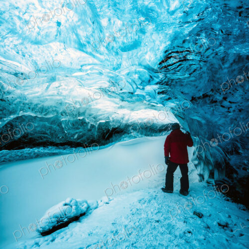Hiker walking in ice cave