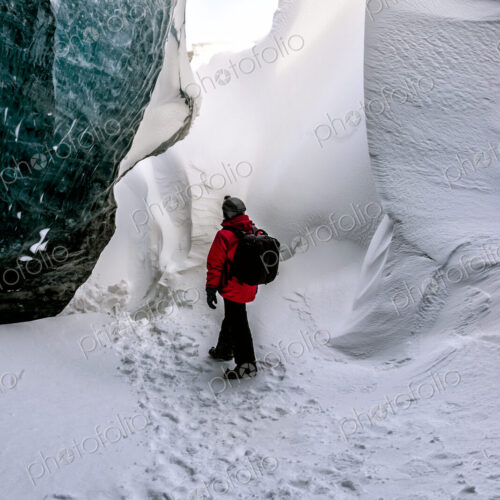 Hiker walking in snowy ice cave Hiker walking in snowy ice cave