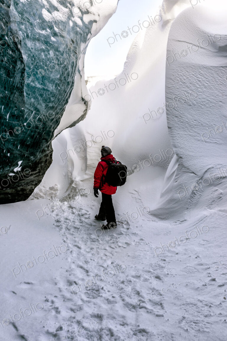 Hiker walking in snowy ice cave