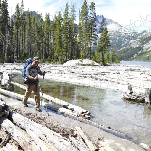 Hiker walking on dirt path by remote lake