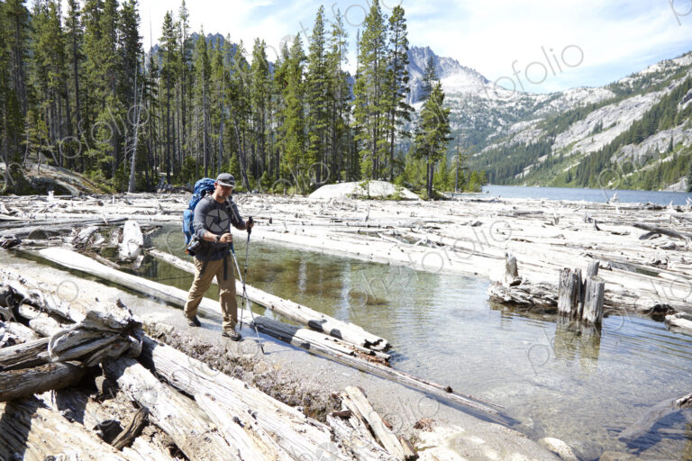 Hiker walking on dirt path by remote lake