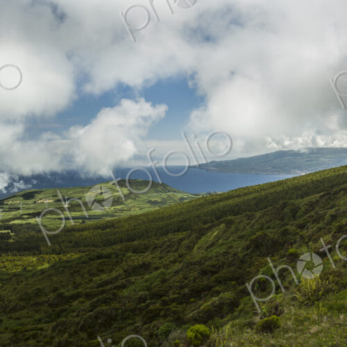 Hiker walking on hilltop dirt path over Cabeco Gordo crater, Faial, Portugal Hiker walking on hilltop dirt path over Cabeco Gordo crater, Faial, Portugal