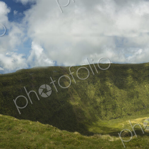 Hiker walking on hilltop dirt path over Cabeco Gordo crater, Faial, Portugal Hiker walking on hilltop dirt path over Cabeco Gordo crater, Faial, Portugal