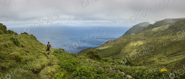 Hiker walking on hilltop path in rural landscape