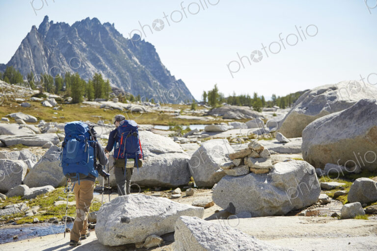 Hikers backpacking in rocky rural landscape