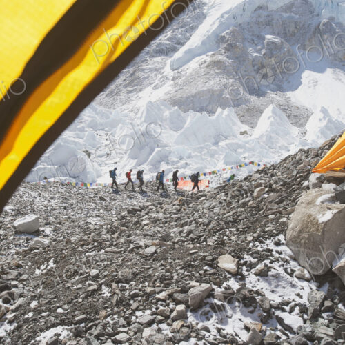 Hikers backpacking on mountain, in a row on a rocky hilltop Hikers backpacking on mountain, in a row on a rocky hilltop