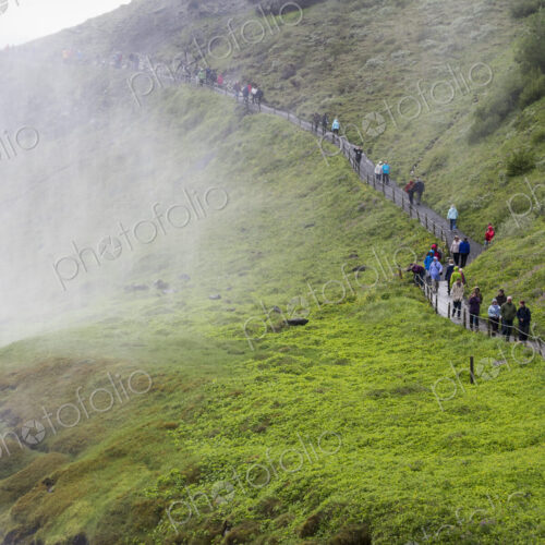 Hikers on the track towards the Gullfoss waterfall.. Mist rising from the gorge.