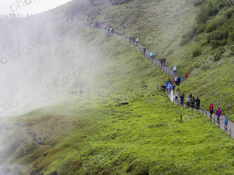 Hikers on the track towards the Gullfoss waterfall.. Mist rising from the gorge.