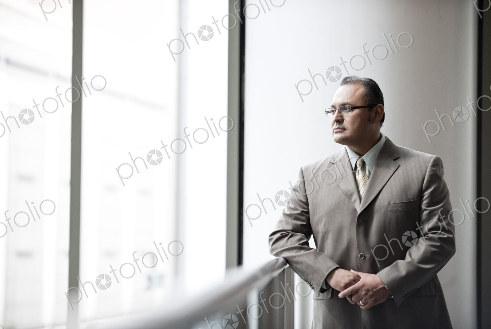 Hispanic busiessman in a shirt and tie standing in a convention center space looking…