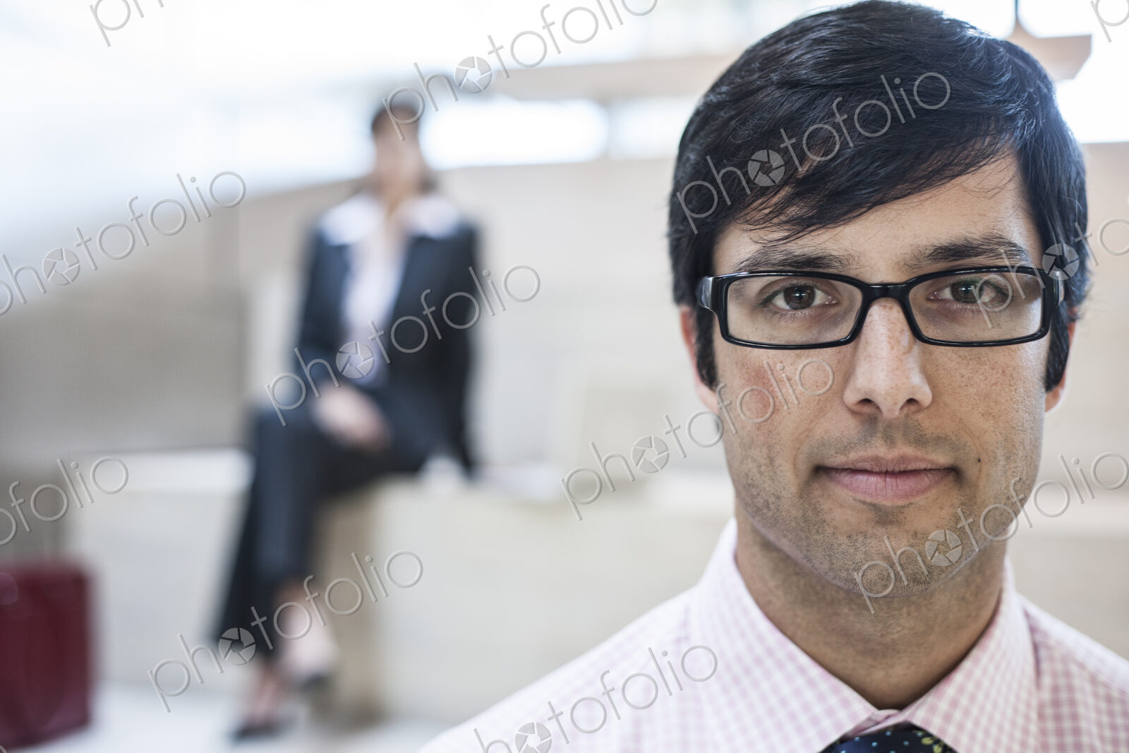 Hispanic business man in an office lobby.