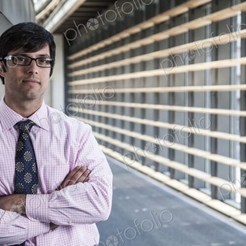 Hispanic business man standing in an office lobby. Hispanic business man standing in an office lobby.