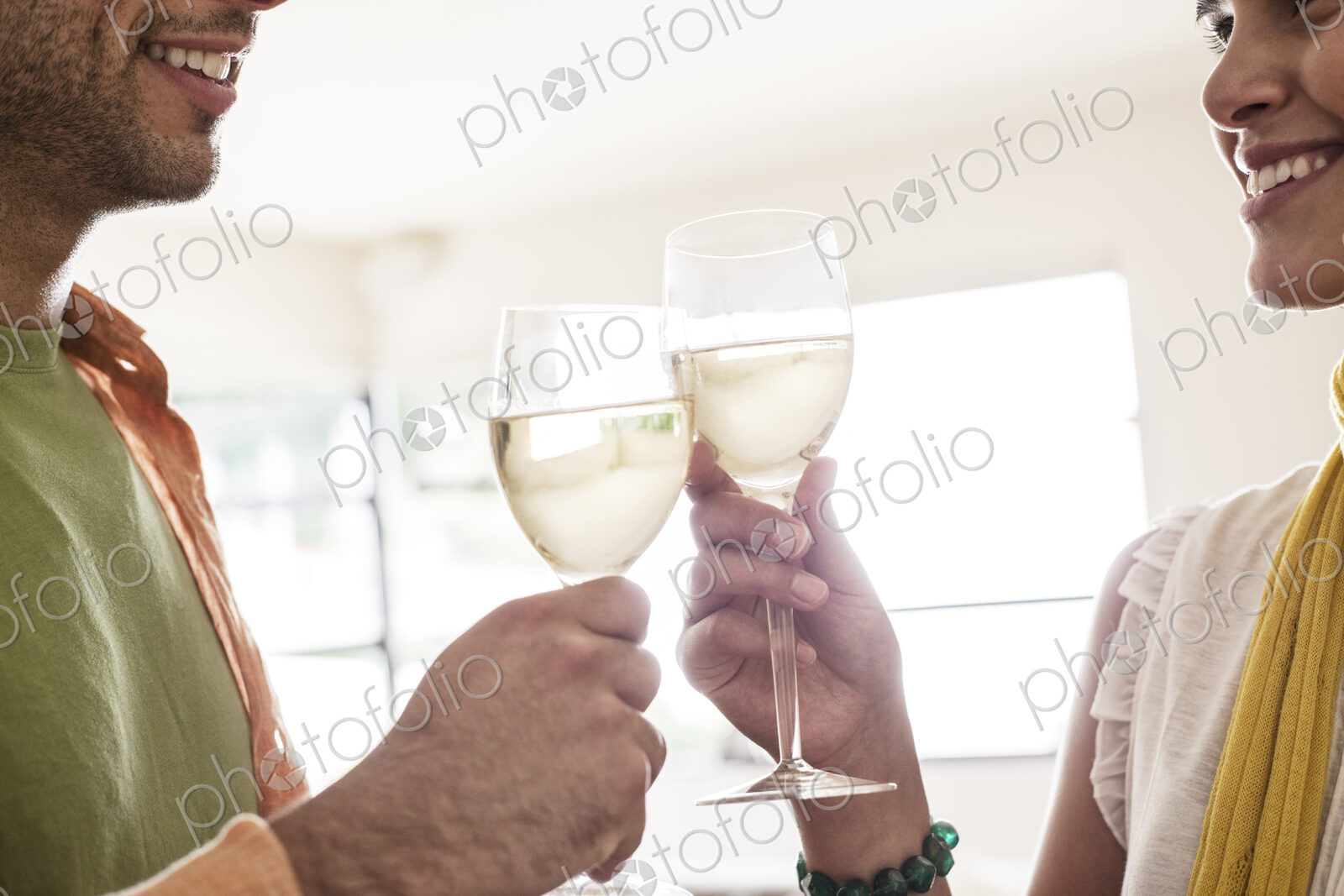 Hispanic couple having a glass of white wine together.
