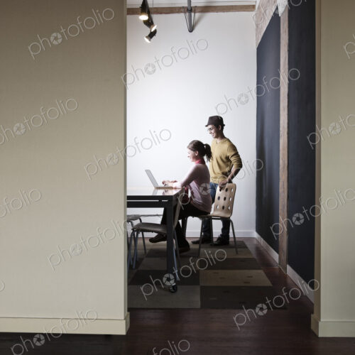 Hispanic male and caucasian female working on a laptop computer in a small conference… Hispanic male and caucasian female working on a laptop computer in a small conference…