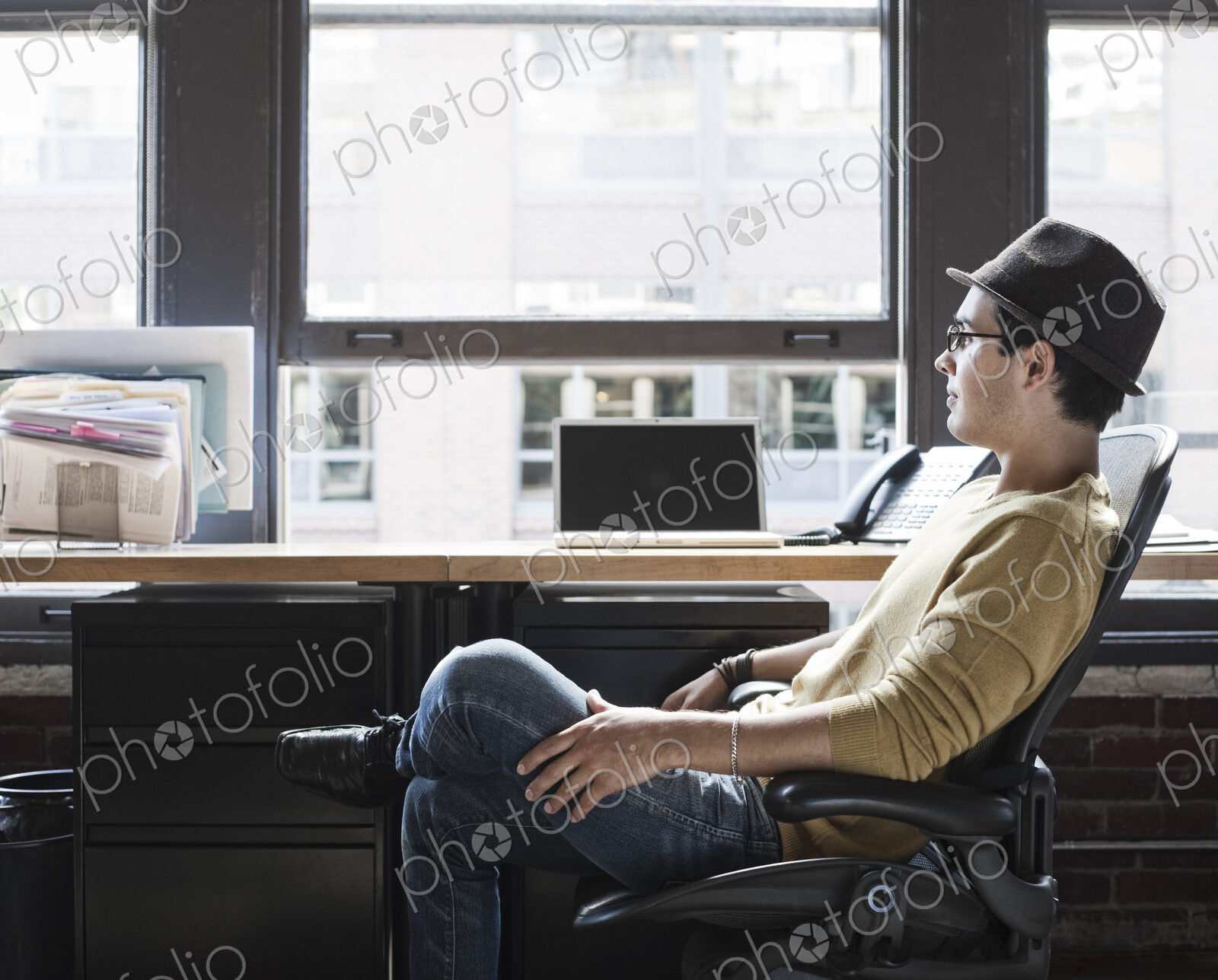 Hispanic male at his office workstation in a creative office.