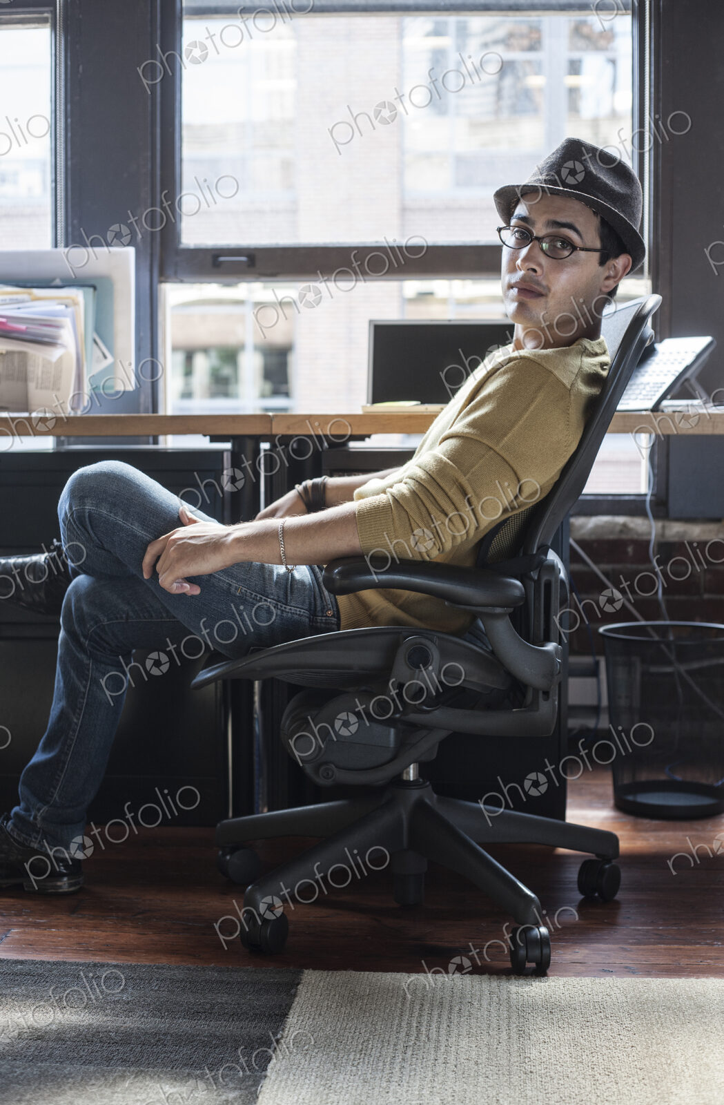 Hispanic male at his office workstation in a creative office.
