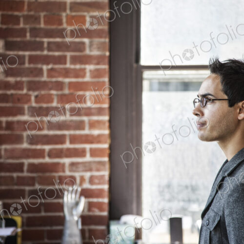 Hispanic male at his office workstation in a creative office. Hispanic male at his office workstation in a creative office.