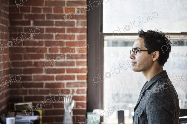 Hispanic male at his office workstation in a creative office.