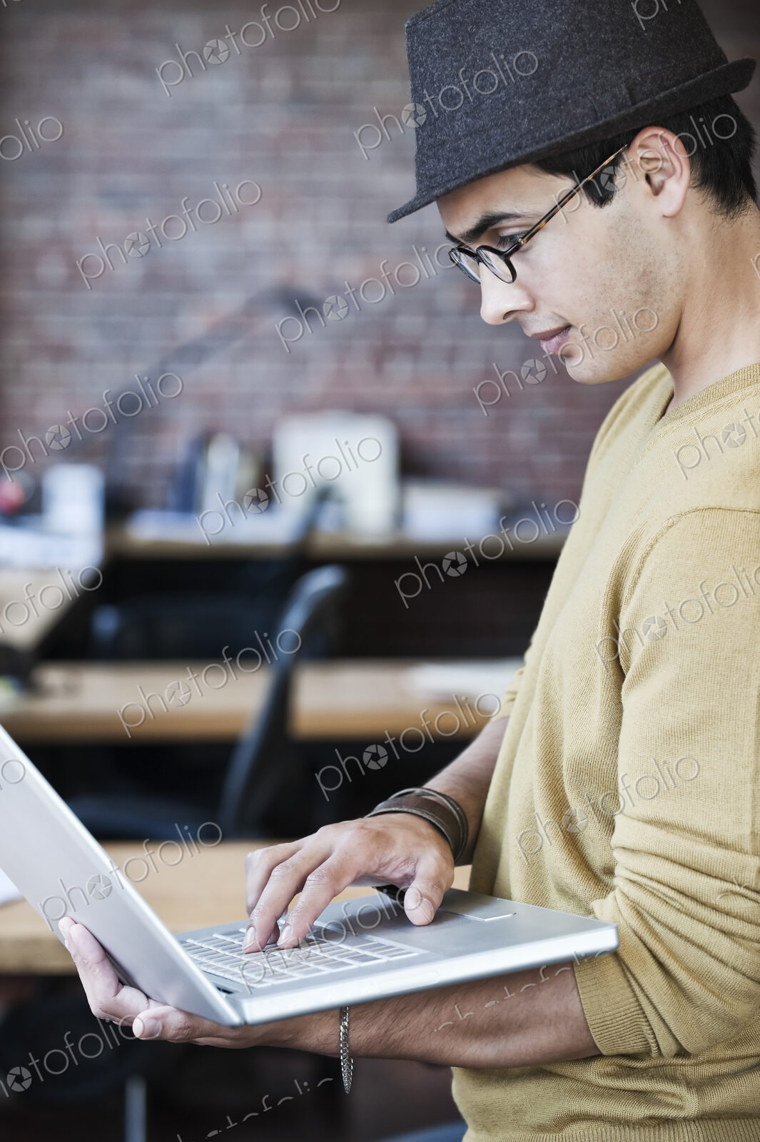 Hispanic male at his office workstation in a creative office.