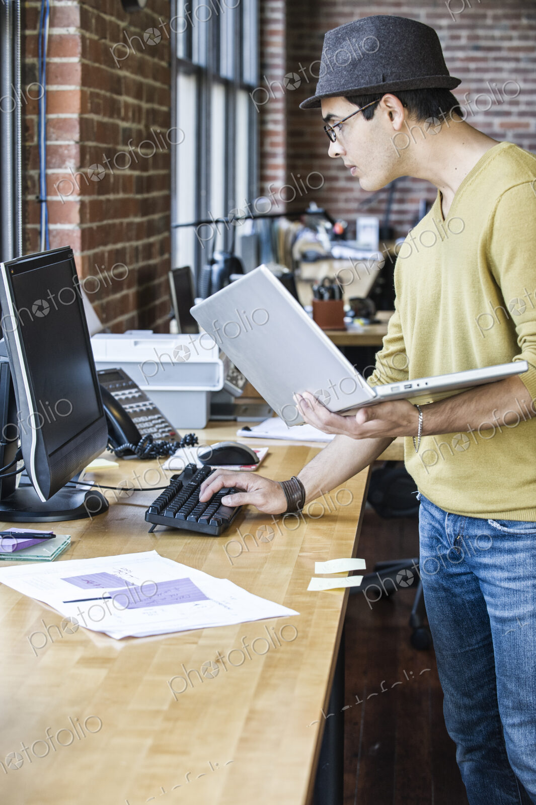 Hispanic male at his office workstation in a creative office.
