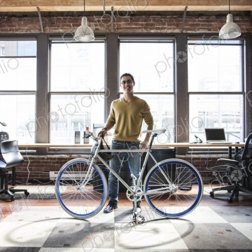 Hispanic man at his office workstation with a bicycle. Hispanic man at his office workstation with a bicycle.
